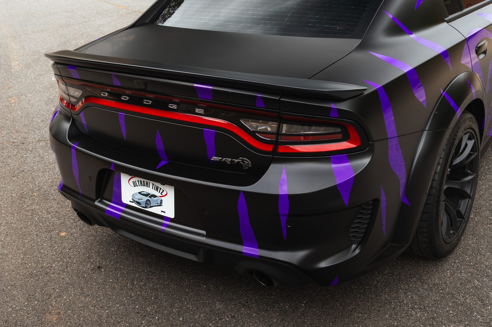 A Dodge Charger in a custom black and purple wrap